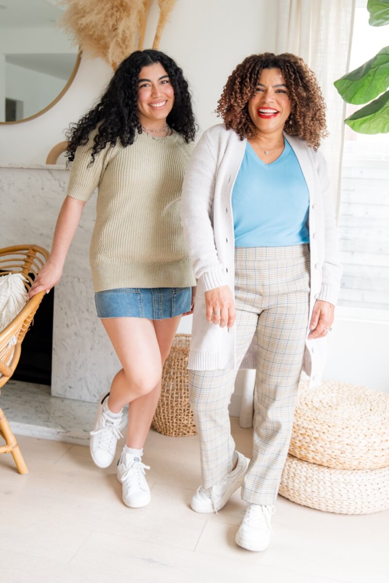 Mom model wearing the Cozy Cardigan in Dove, Serenity Tee in Storm Blue, and the Trubute Trouser in Effortless Plaid. Daughter model wearing Speedway Skirt in Retro Wash and the Tranquil Pullover in Fleck Gray