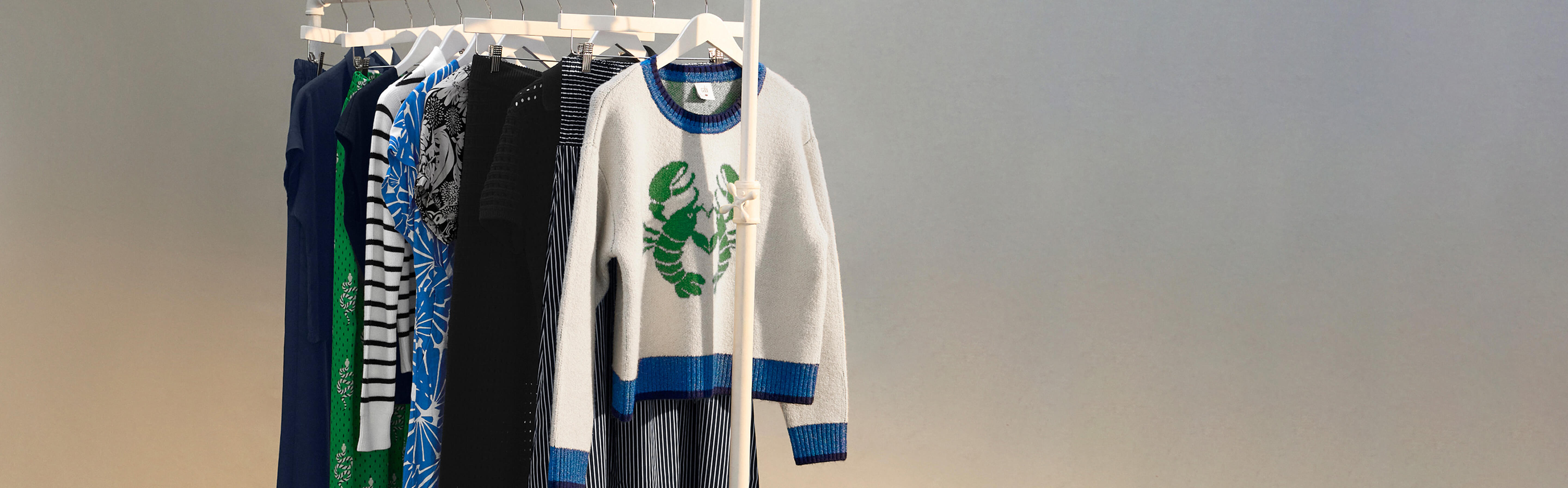 Clothing rack with various New Arrivals clothes on it