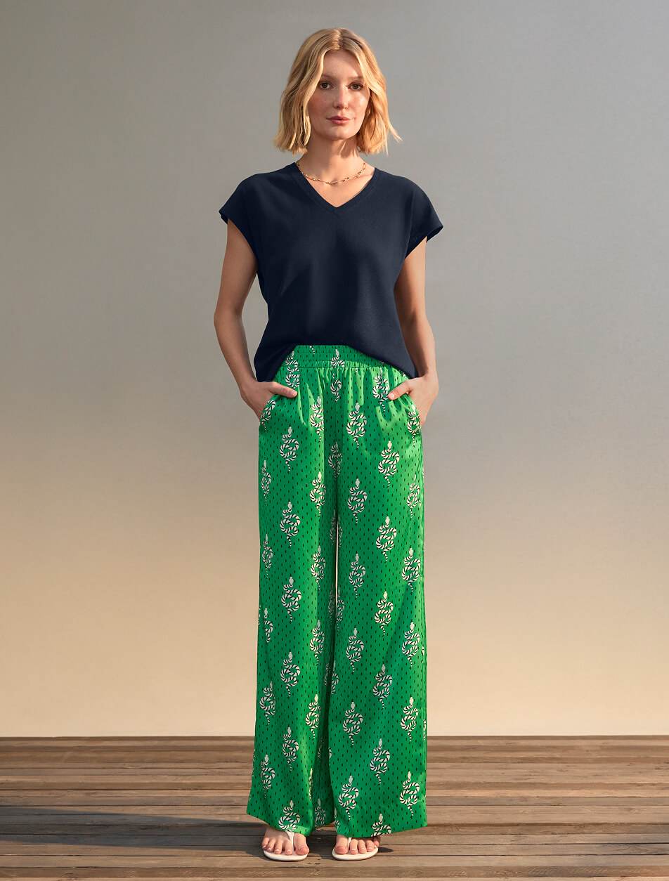 Female wearing a black top and green pants